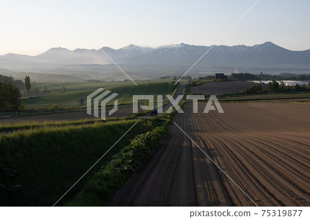 Scenery of Kamifurano Town and Tokachidake Mountain Range in summer Scenery of Kamifurano Town and Tokachidake Mountain Range in summer 75319877
