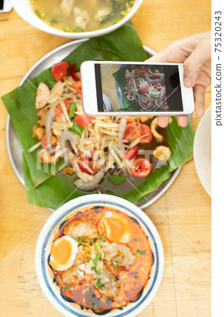 Smart Phone takes photo of Spicy Papaya Salad and Tomyum spice Soup Smart Phone takes photo of Spicy Papaya Salad and Tomyum spice Soup 75320243