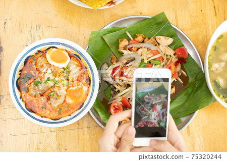 Smart Phone takes photo of Spicy Papaya Salad and Tomyum spice Soup Smart Phone takes photo of Spicy Papaya Salad and Tomyum spice Soup 75320244