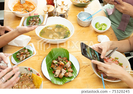 Girl takes photo with smart phone of Delicious and good looking Food Girl takes photo with smart phone of Delicious and good looking Food 75320245