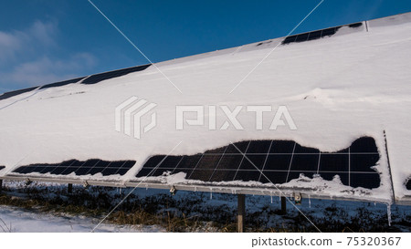 A layer of snow on the panels of a solar power plant. Green energy problems and weather dependence A layer of snow on the panels of a solar power plant. Green energy problems and weather dependence 75320367