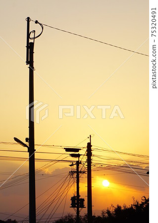 Telephone poles and the setting sun. Telephone poles and the setting sun. 75320491