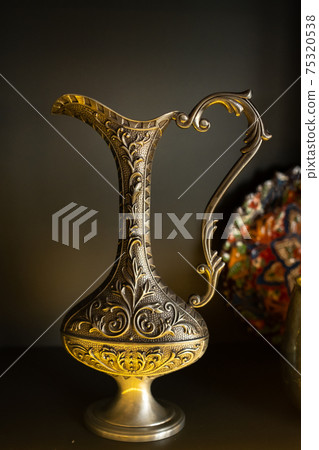 Old copper jug from the east on a black background Old copper jug from the east on a black background 75320538