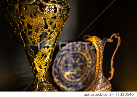 Old copper jug from the east on a black background Old copper jug from the east on a black background 75320540