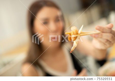 Woman eats Chili Fresh Pawn and hanging on chopstick Woman eats Chili Fresh Pawn and hanging on chopstick 75320551
