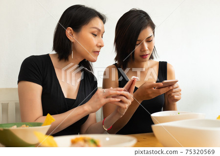 Girl takes photo with smart phone of Delicious and good looking Food Girl takes photo with smart phone of Delicious and good looking Food 75320569