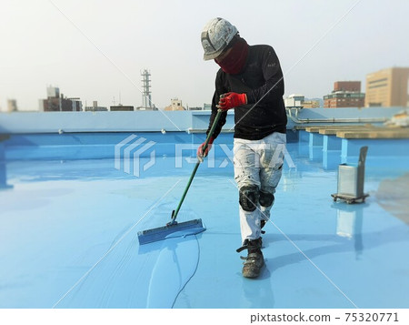 一名男性工匠在 RC 建築的屋頂板上應用聚氨酯防水材料 75320771