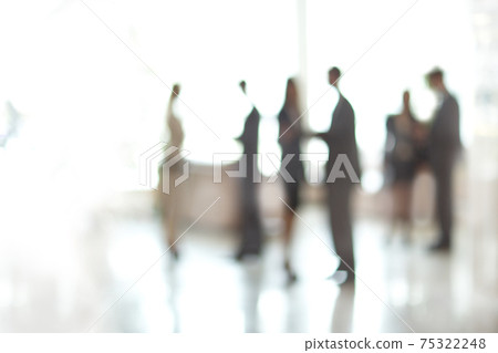 blurry image of a group of business people standing in the office lobby. blurry image of a group of business people standing in the office lobby. 75322248