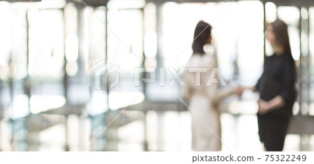 blurry image of two business women meeting each other with a handshake. blurry image of two business women meeting each other with a handshake. 75322249