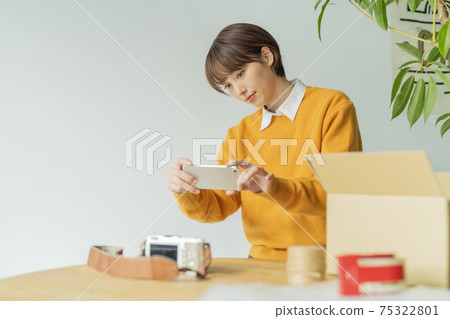 Woman taking a picture of a product 75322801
