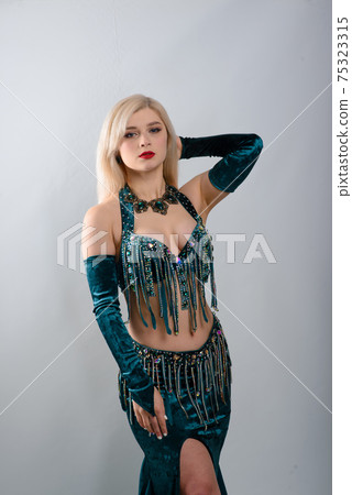Young beautiful exotic eastern women performs belly dance in ethnic green dress. Young beautiful exotic eastern women performs belly dance in ethnic green dress. 75323315