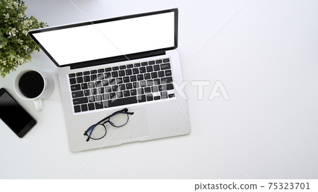 Overhead shot of mock up computer laptop, smart phone, coffee cup and copy space on white background. Overhead shot of mock up computer laptop, smart phone, coffee cup and copy space on white background. 75323701