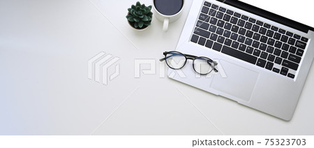Horizontal photo of computer laptop, glasses, coffee cup and copy space on white background. Horizontal photo of computer laptop, glasses, coffee cup and copy space on white background. 75323703