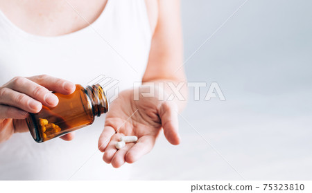 Medical pills tablets in a bottle on a female hand. Health and medicine 75323810