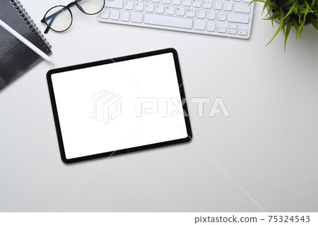 Above view of digital tablet with empty screen on white office desk. Above view of digital tablet with empty screen on white office desk. 75324543
