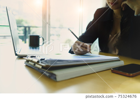 Close up view of businesswoman holding pen signing on document. Close up view of businesswoman holding pen signing on document. 75324676