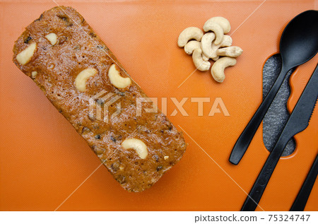 Homemade Rawa and cashew nuts cake on Orange coloured chopping board Homemade Rawa and cashew nuts cake on Orange coloured chopping board 75324747