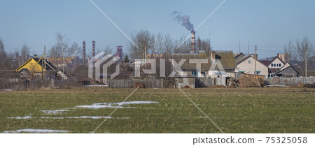village house on the background of an industrial factory. village house on the background of an industrial factory. 75325058