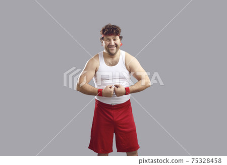 Happy man in tank top and shorts smiling and flexing his arms showing his muscles Happy man in tank top and shorts smiling and flexing his arms showing his muscles 75328458