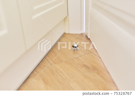 Metal door stopper built into wood floor 75328767