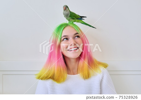 Trendy fashionable with colored hairstyle teenager with green parrot on head Trendy fashionable with colored hairstyle teenager with green parrot on head 75328926