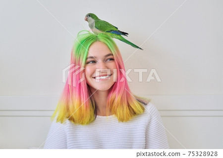 Trendy fashionable with colored hairstyle teenager with green parrot on head Trendy fashionable with colored hairstyle teenager with green parrot on head 75328928