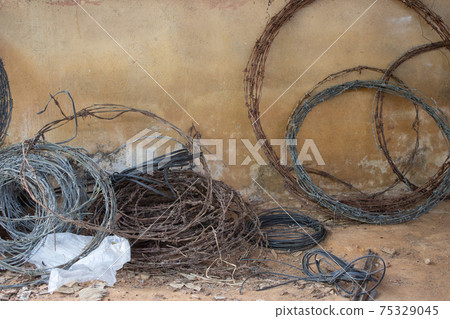 Rolls of used barbed wire used for building cattle fences Rolls of used barbed wire used for building cattle fences 75329045