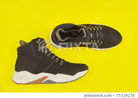 New womens leather black waterproof hiking winter autumn boots on yellow background New womens leather black waterproof hiking winter autumn boots on yellow background 75329270