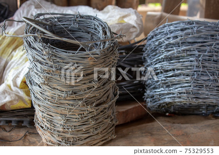 Rolls of barbed wire used for building cattle fences Rolls of barbed wire used for building cattle fences 75329553