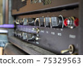 Buttons, knobs and lights of a guitar amplifier 75329563