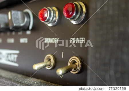 Buttons, knobs and lights of a guitar amplifier Buttons, knobs and lights of a guitar amplifier 75329566