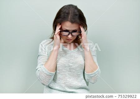 Portrait of alone sad mature woman with glasses on green background 75329922