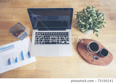 Office laptop business financial document chart and graph on wooden table with coffee cup. Flat lay notebook computer laptop on office desk. No people business graph chart mockup on business workspace Office laptop business financial document chart and graph on wooden table with coffee cup. Flat lay notebook computer laptop on office desk. No people business graph chart mockup on business workspace 75330141