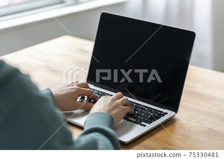 Hand of a young man operating a laptop 75330481