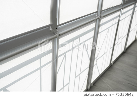 White fabric roller blinds on the plastic window on a balcony in the living room. 75330642
