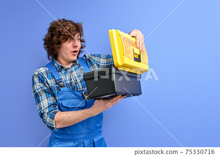 young caucasian curly rapirman opening tools box, look at instruments 75330716