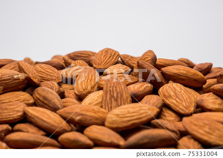 Whole almond nuts on the white background. Healthy vegetarian snack. Close-up photo. Space for your text. Whole almond nuts on the white background. Healthy vegetarian snack. Close-up photo. Space for your text. 75331004