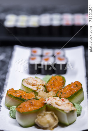 set of sushi rolls with seafood on a black stone background set of sushi rolls with seafood on a black stone background 75331204