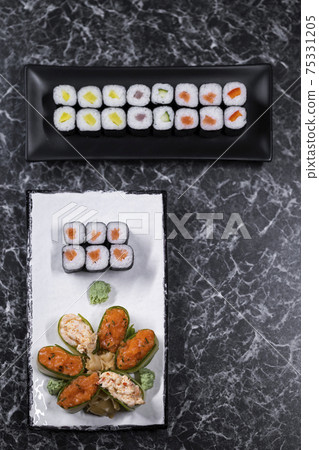 set of sushi rolls with seafood on a black stone background set of sushi rolls with seafood on a black stone background 75331205
