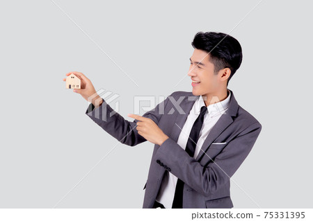Young asian business man holding the home symbol of saving for future, insurance agent and credit. Young asian business man holding the home symbol of saving for future, insurance agent and credit. 75331395