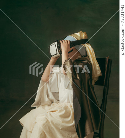 Medieval little girl as a lady with a pearl earring on dark studio background. Concept of comparison of eras, childhood. Stylish creative design, art vision, new look of artwork. Medieval little girl as a lady with a pearl earring on dark studio background. Concept of comparison of eras, childhood. Stylish creative design, art vision, new look of artwork. 75331443