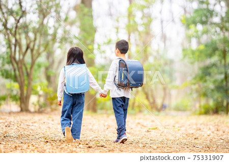 Brother and sister park school bag holding hands 75331907