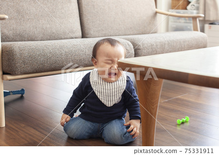 Baby hitting his head against the corner of the table 75331911