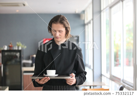 Handsome male barista is working in coffee shop Handsome male barista is working in coffee shop 75332117