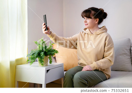 Young blone woman taking selfie at home Young blone woman taking selfie at home 75332651