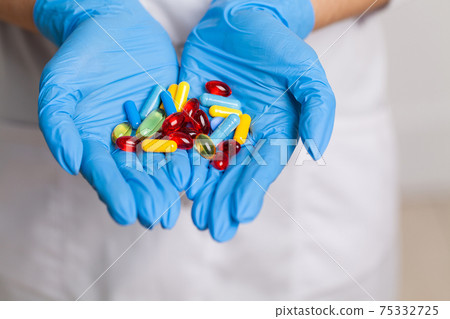 Doctor close up holding white pills for weight loss 75332725