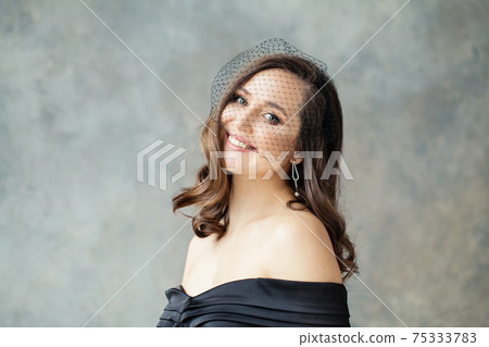 Attractive brunette model woman smiling on gray background Attractive brunette model woman smiling on gray background 75333783