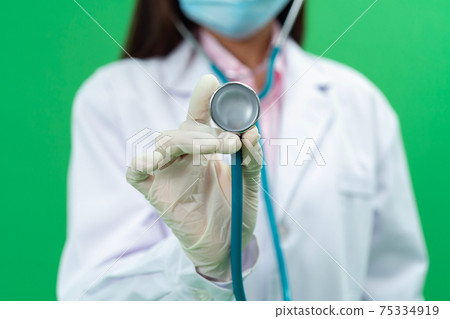 Female doctor holding metal medical stethoscope doctor equiptment tool ,healthcare concept isolated on green background in healthcare concept. Female doctor holding metal medical stethoscope doctor equiptment tool ,healthcare concept isolated on green background in healthcare concept. 75334919