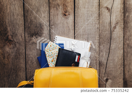 Flat lay travel concept, passport, wallet, bag, mask, notepad, wooden background Flat lay travel concept, passport, wallet, bag, mask, notepad, wooden background 75335242
