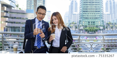 Banner Businessman Businesswoman drinking coffee in town using smartphone outside office city. Panorama Hands holding take away coffee cup, smart phone talking together Business partner copyspace Banner Businessman Businesswoman drinking coffee in town using smartphone outside office city. Panorama Hands holding take away coffee cup, smart phone talking together Business partner copyspace 75335267